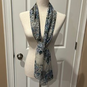 A polyester scarf with tan, blue, brown, and gray colors.